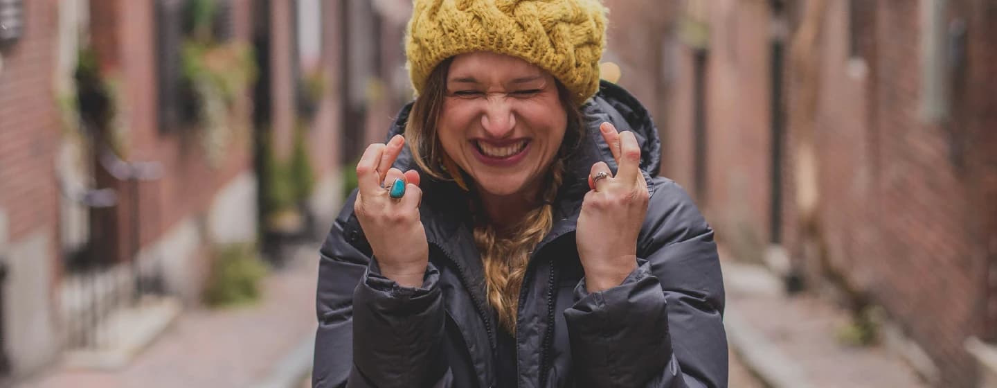 woman crossing fingers, representing firefish's 5 awards shortlist nominations in 2022 for research excellence