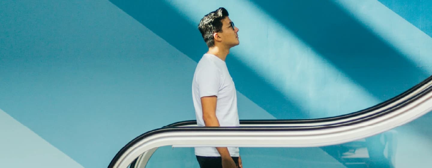 a man going up an escalator representing dan rose's promotion to managing director uk